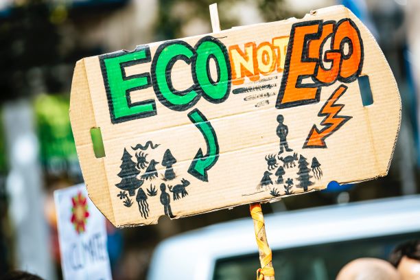 Person holding eco-not-ego sign