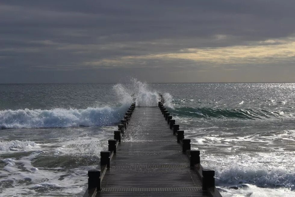 Sea waves break on wooden sea pier