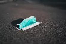 Medical face mask on the ground. Maybe worn by a person who tried to protect him/herself from corona virus.