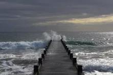 Sea waves break on wooden sea pier